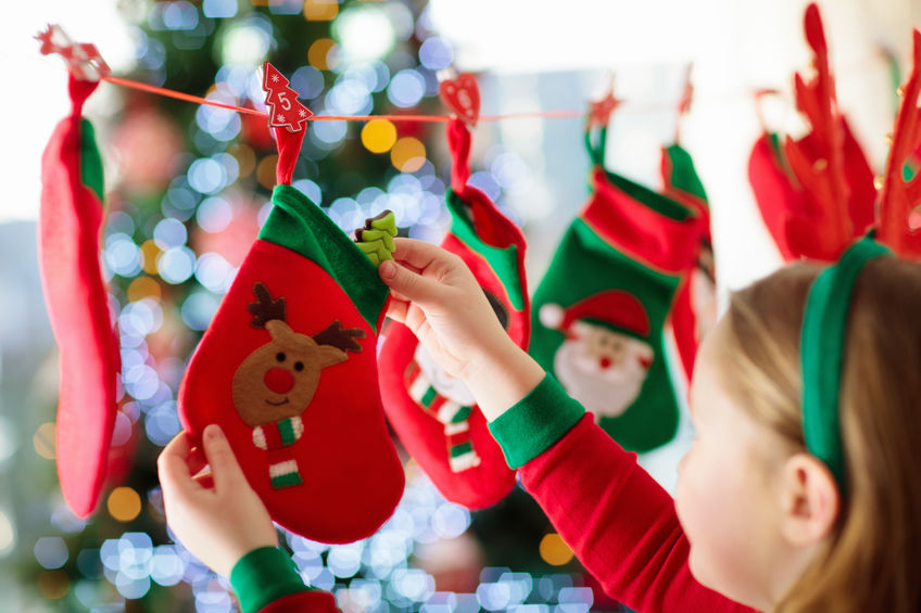 Niña decorando con zapato navideño