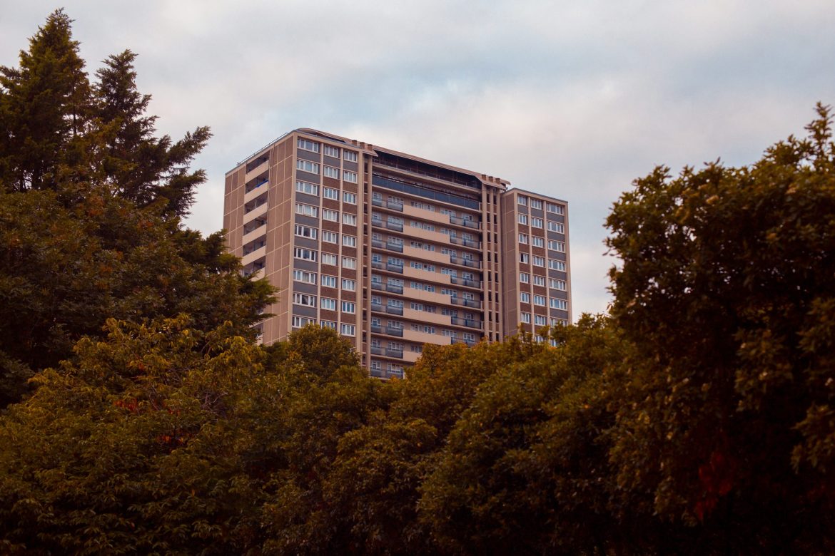Edificio residencial en Madrid rodeado de árboles, ideal para ilustrar el cambio de vivienda en Madrid por el clima y opciones de barrio con Redpiso