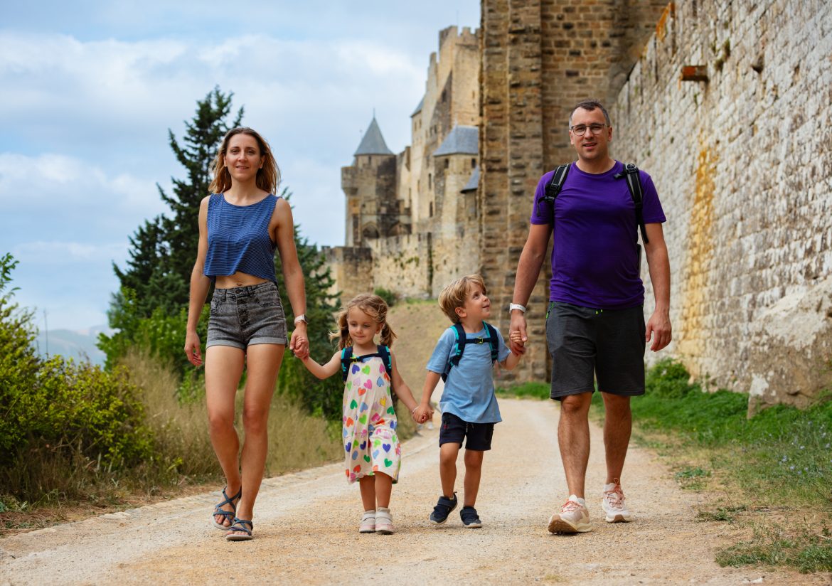 Familia paseando junto a una muralla medieval durante una escapada de fin de semana desde Madrid