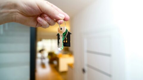 Propietario con las llaves en la puerta de su piso, dudando entre vender o alquilar piso en 2026